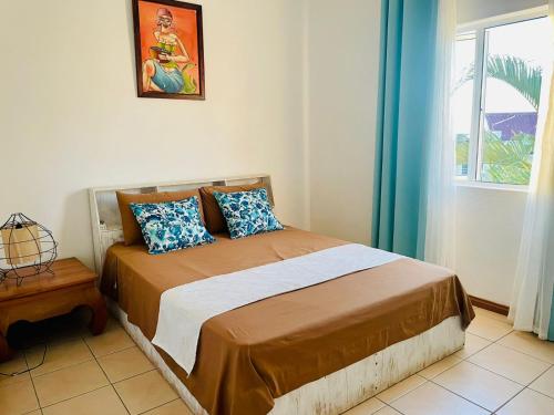 a bedroom with a bed with blue curtains and a window at Secure villa in a quiet garden with pool in Albion
