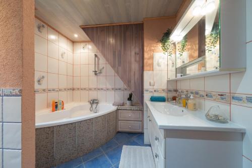 a bathroom with two sinks and a bath tub at Chez Corinne in Cornimont