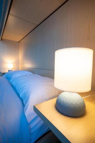 a lamp on a table next to a bed at Casa Gelsomina in Isola Bacucco