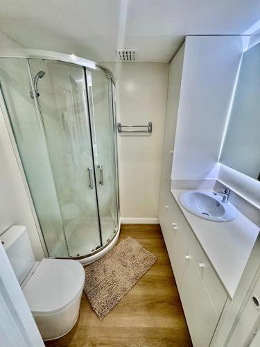 a bathroom with a shower and a toilet and a sink at Mediterráneo Suites Port in Jávea