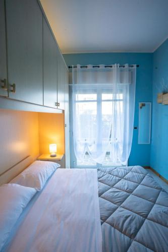 a bedroom with a large white bed and a window at Casa Gelsomina in Isola Bacucco