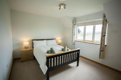 a bedroom with a large bed and a window at Nistagar, Harray, Orkney - OR00604F in Harray
