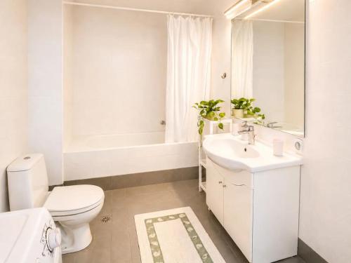 a white bathroom with a toilet and a sink at Aquarius Kefalonia in Pesádha