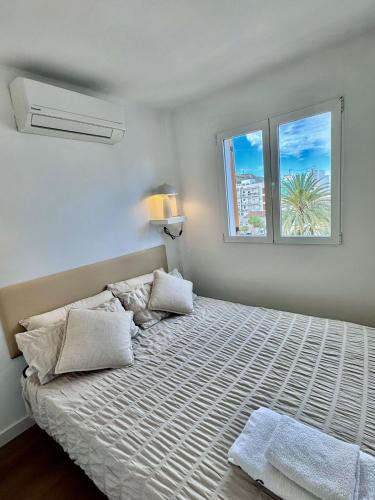 a bedroom with a large bed with two windows at Mediterráneo Suites Port in Jávea