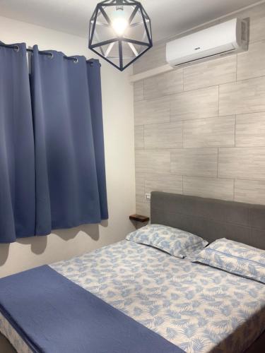 a bedroom with a bed and a blue curtain at Da Michele 2 in Costa Rei