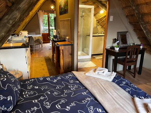 a bedroom with a bed and a desk and a kitchen at Baldinnie Cottages in Nottingham Road