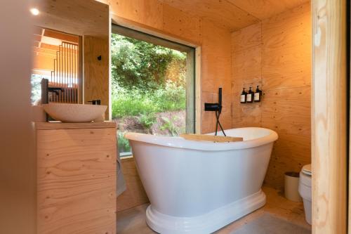 a large tub in a bathroom with a window at White House Hideaway in Brockhampton