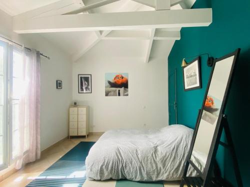 a bedroom with a bed and a blue wall at Marina with pool in Aigues-Mortes