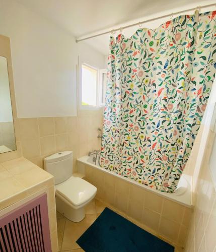 a bathroom with a toilet and a shower curtain at Marina with pool in Aigues-Mortes