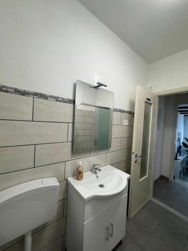 a bathroom with a sink and a toilet and a mirror at Hi Malpensa - Apartment in Case Nuove