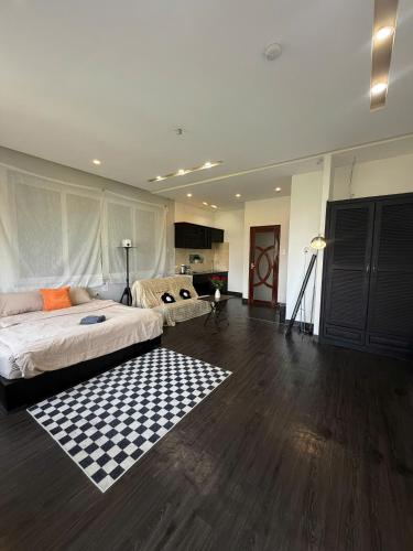 a large bedroom with a bed and a checkered rug at MiMo Homestay Đà Lạt in Xuan An