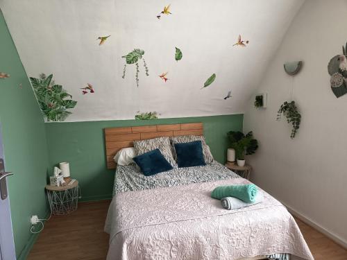a bedroom with a bed with plants on the wall at Chambres d'hôtes des Bruyères in Collemiers