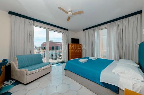 a bedroom with a bed and a chair and a window at B&B Casa di Emma in Porto Cesareo