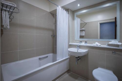 a bathroom with a sink and a tub and a toilet at The Victoria Hotel in Galway