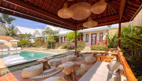 an outdoor patio with a swimming pool and a house at Bacana Bungalows in Uluwatu