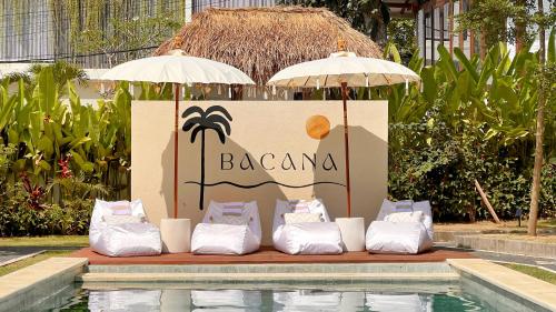 a group of pillows and umbrellas next to a pool at Bacana Bungalows in Uluwatu