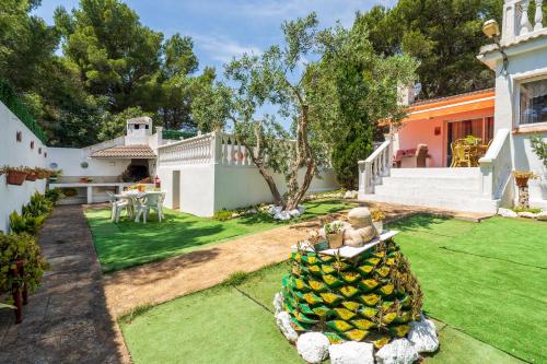 a yard with a pineapple sculpture in the yard at Hauzify I Casa Peralta in Les tres Cales