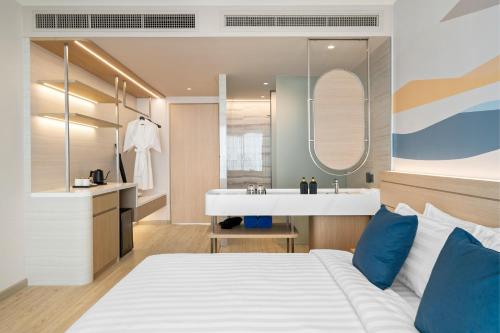 a bedroom with a bed and a bathroom with a sink at BTP Hotel Nakhon Phanom in Ban Noi Pho Kham