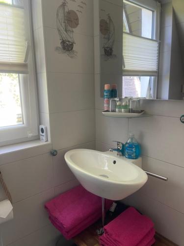 a bathroom with a white sink and pink towels at Ferienhaus nähe Warnemünde in Elmenhorst