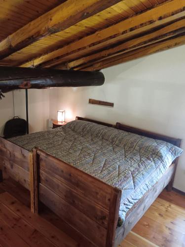 a bedroom with a wooden bed in a attic at La casetta di Marmora in Marmora