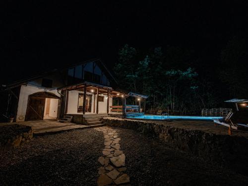 a small house with a swimming pool at night at villa vidalis in Veliko Golovode