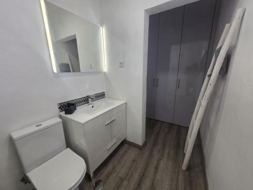 a bathroom with a toilet and a sink and a mirror at Villa Mares in Casas Novas de Marés