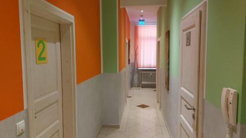 a hallway with green and orange walls and two doors at FineApartment Rendsburg in Rendsburg