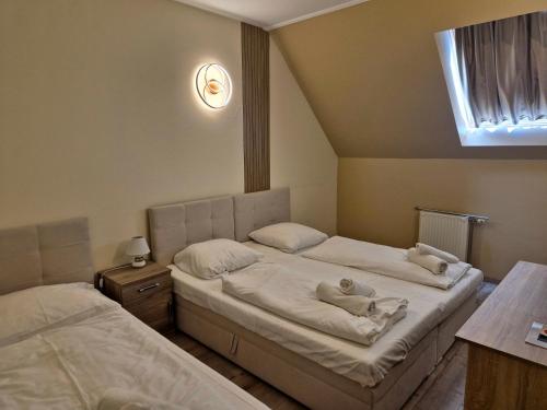 a bedroom with two beds and a window at Hotel Korona in Siófok