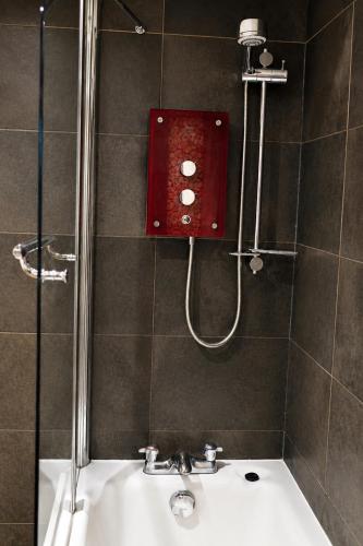 a bathroom with a shower and a white sink at Eryri Golden Stays in Capel Garmon