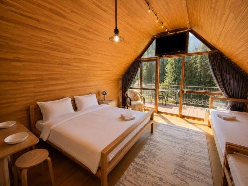 a bedroom with a bed and a large window at Kolsay Tanbalytas A-Frame in Kolʼbastau