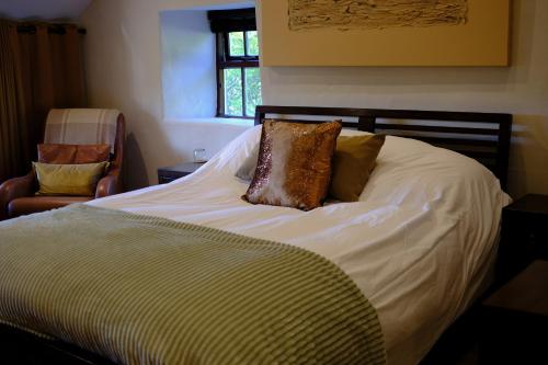 a bed with two pillows on it in a bedroom at Eryri Golden Stays in Capel Garmon