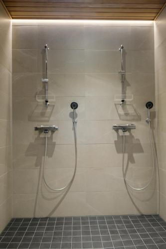 a bathroom with a shower with two faucets at Villa Arvonpiha A in Tahkovuori
