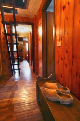 a room with a wooden floor and a ladder at Champoluc Apartment in Champoluc