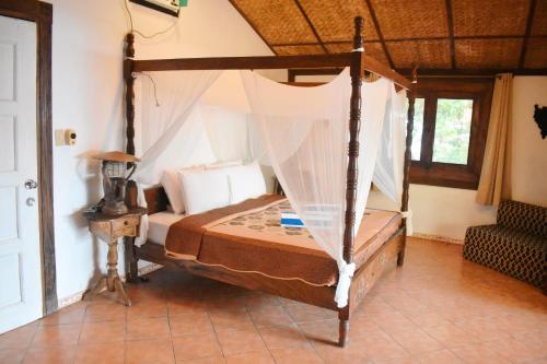 a bedroom with a bed with a canopy at M Villa’s Farm Resort in Romblon