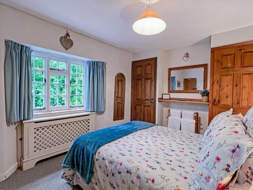 a bedroom with a bed and a window at Ruffles Cottage Dunster in Dunster