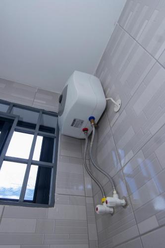 a white shower in a bathroom with a window at JJC BNB Mbweni in Bunju
