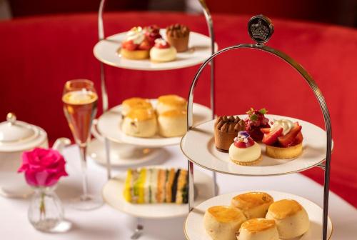 a table with plates of pastries and drinks on plates at Hotel Cafe Royal in London