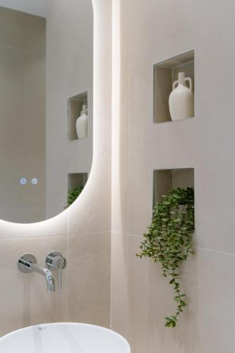 a bathroom with a sink and a mirror and a plant at Fissas Rooms in Syvota