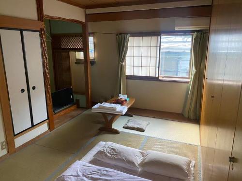 a room with two beds and a table and a window at 静佳民宿 in Osaka