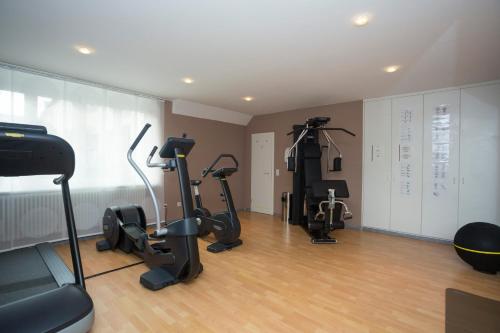 a gym with treadmills and exercise bikes in a room at Stadthotel Freiburg Kolping Hotels & Resorts in Freiburg im Breisgau