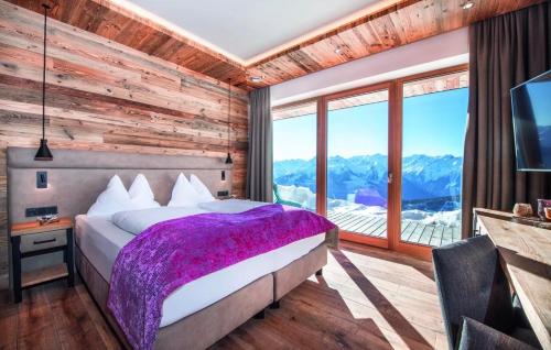 a bedroom with a bed and a large window at Panorama Alm in Jochberg
