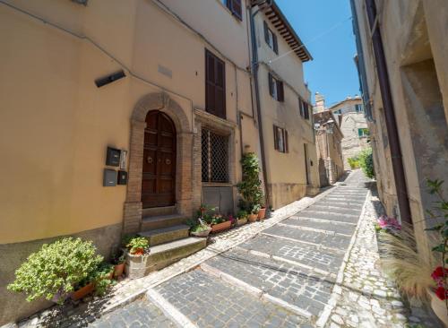 an alley in an old building with a door and plants at Malù Cozy Borgo Retreat in Casperia