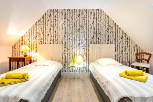 two twin beds in a room with a wallpaper at Entre mer et rivière in Moëlan-sur-Mer