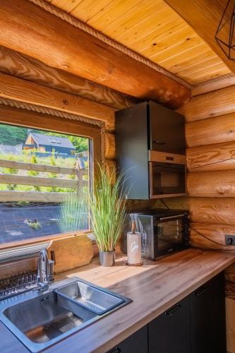 a kitchen with a sink and a window at Bali domy RESORT & SPA in Laskowa