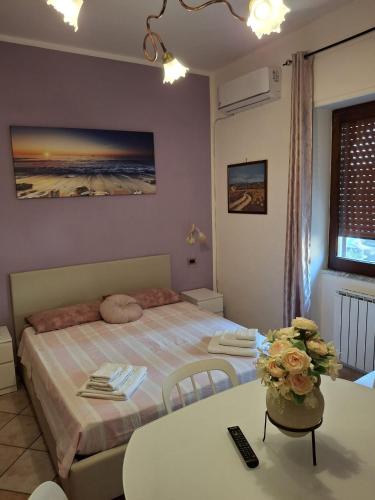 a bedroom with a bed and a table and a table and chairs at Casa Vacanze Nantò 2 in Santa Maria di Castellabate
