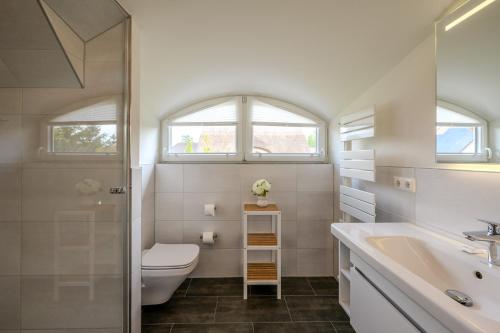 a bathroom with a toilet and a sink at Traumgarten Haus Leichte Brise in Prerow