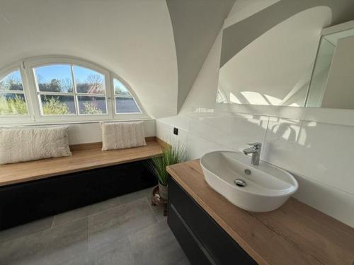 a bathroom with a sink and a window at Ferienhaus Sarcander in Glowe