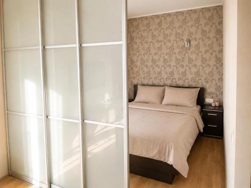 a bedroom with a bed and a white closet at Nikoletos apartamentai in Panevėžys