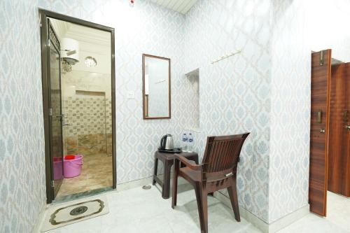 a bathroom with a desk and a chair and a shower at Shiv Kothi Home Stay in Varanasi