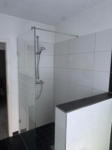 a glass shower in a bathroom with a black tile floor at Lingen Stay 2 in Lingen